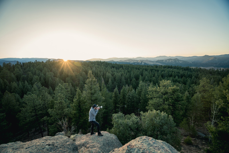Brian photographing a mountain sunset from a rocky overlook